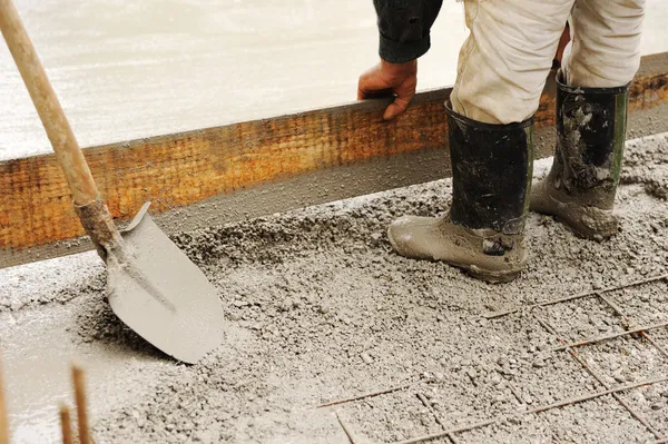 Людина вирівнювання бетонної плити — стокове фото