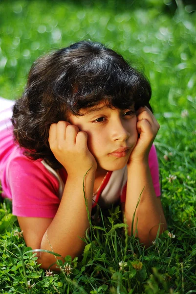 Chica en la hierba mirando — Foto de Stock