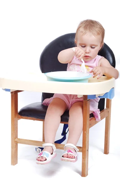 Baby sitting on the black chair isolated — Stock Photo, Image