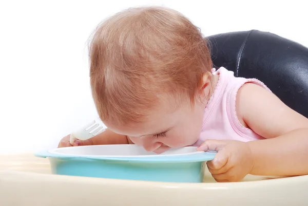 Baby sitting on the black chair eating — Stock Photo, Image