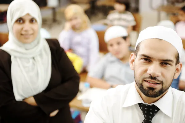 穆斯林男性和女性教师在教室里与儿童 — 图库照片