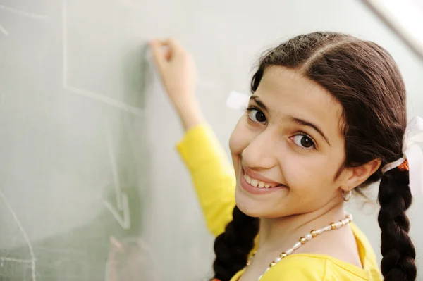 Nádherná dívka, psaní na tabuli ve třídě — Stock fotografie