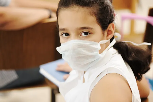 Schoolmeisje met geneeskunde masker op het gezicht, in de klas, tegen: virus, ziek, e — Stockfoto