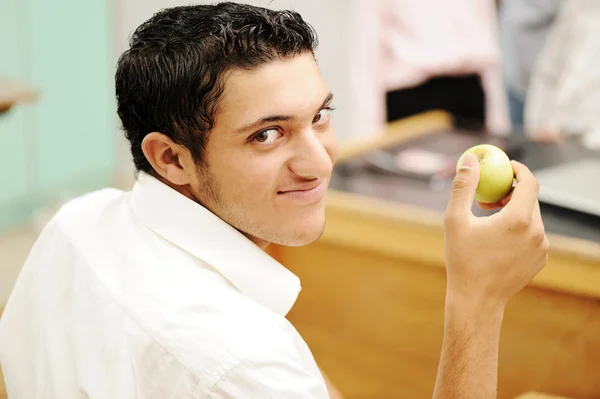 Student in collage with an apple in hand smiling — Stock Photo, Image