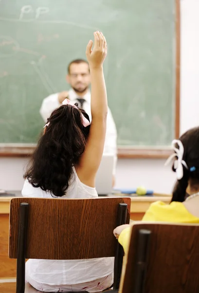 Lehrer und Schüler in der Schule, die Hand hebt und antwortet — Stockfoto