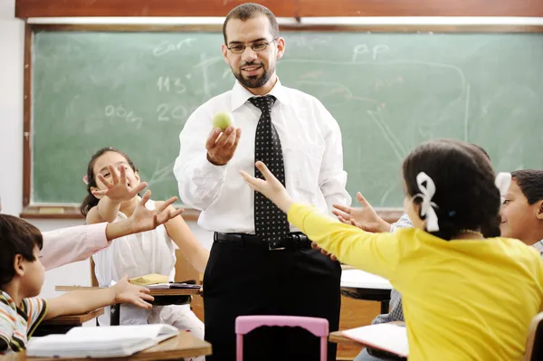 Молодой учитель-мужчина с детьми в современной школе, занятия — стоковое фото