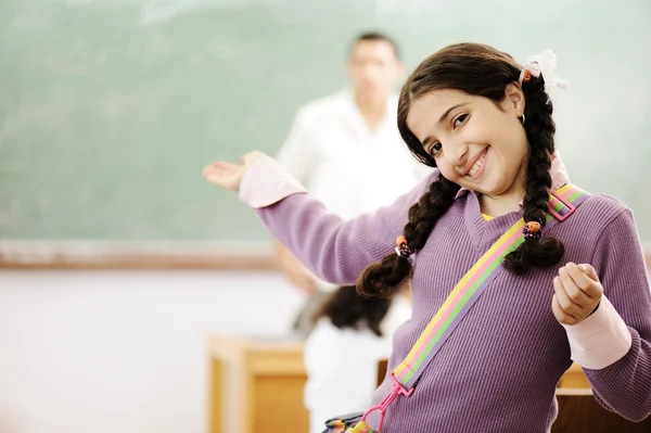 Välkommen till min skola: bedårande skolflicka leende i klassrummet och lärare — Stockfoto