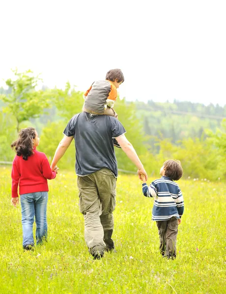 Familia feliz en la naturaleza, padre e hijos caminando — Foto de Stock