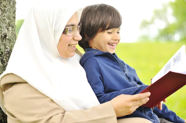 Mamma muslim och hennes son i naturen, läsa tillsammans — Stockfoto