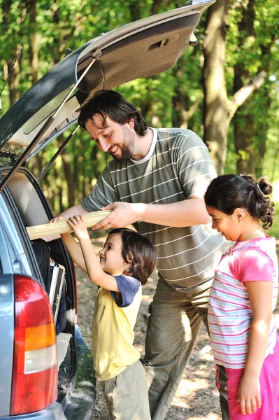 Familie met auto in de natuur — Stockfoto