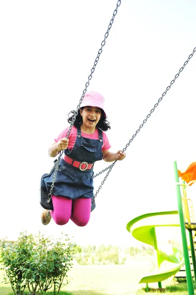 On the playground, swinging — Stock Photo, Image