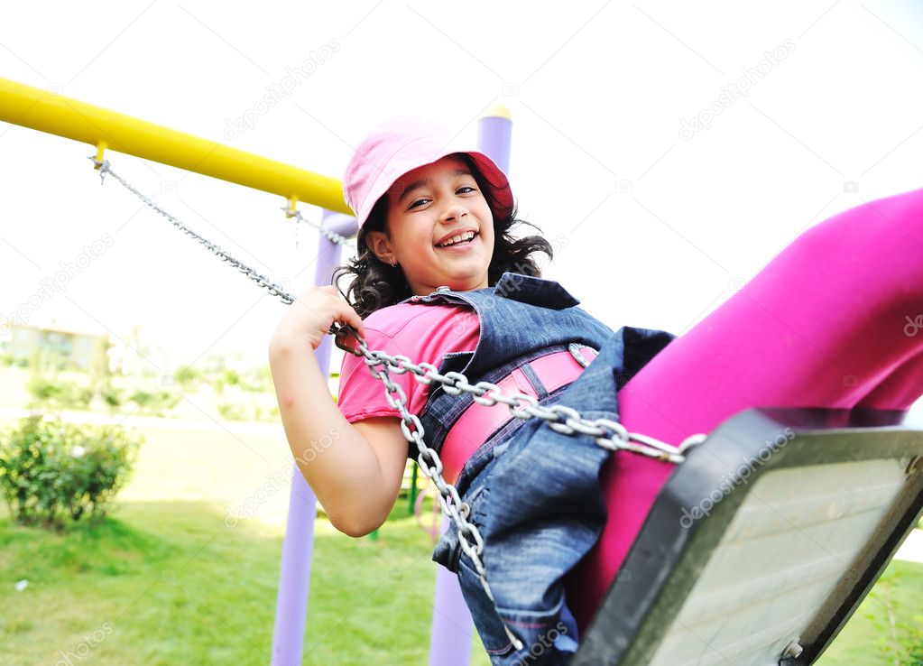 On the playground, swinging