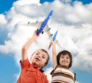 Two small boys with airplains in hands, idea for traveling around the World clipart