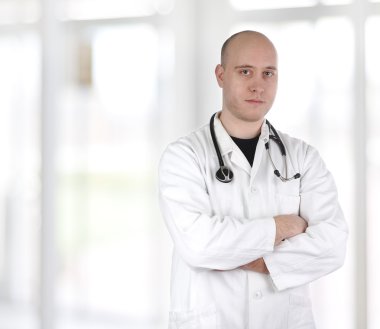 Smiling confident doctor standing with hands crossed isolated on white back clipart