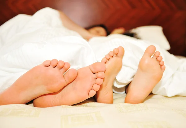 Casal encantador na cama, foco em pés — Fotografia de Stock