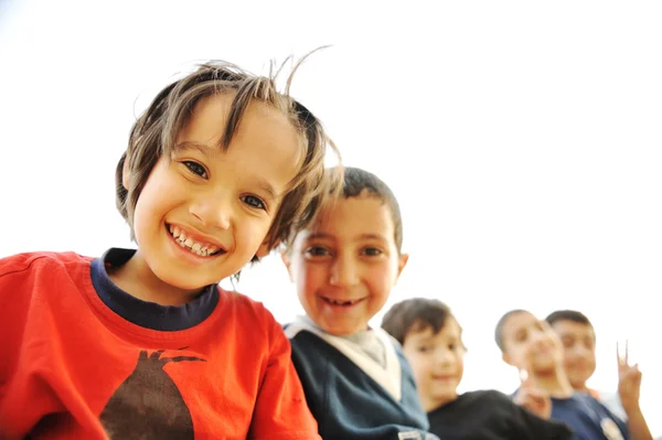 Abaixo vista de crianças felizes abraçando uns aos outros e sorrindo para a câmera — Fotografia de Stock
