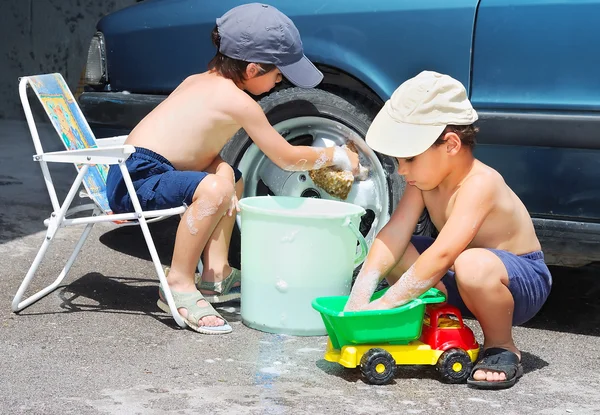 Двое детей ждут машину и игрушечный автомобиль — стоковое фото