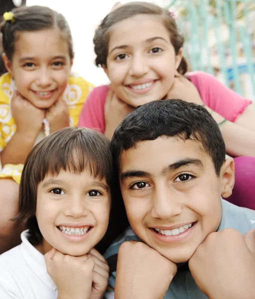 Foto vertical de grupo de crianças, quatro amigos sorrindo ao ar livre, meninos e gi — Fotografia de Stock