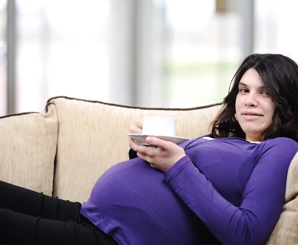 Szczęśliwa kobieta w ciąży na kanapie — Zdjęcie stockowe