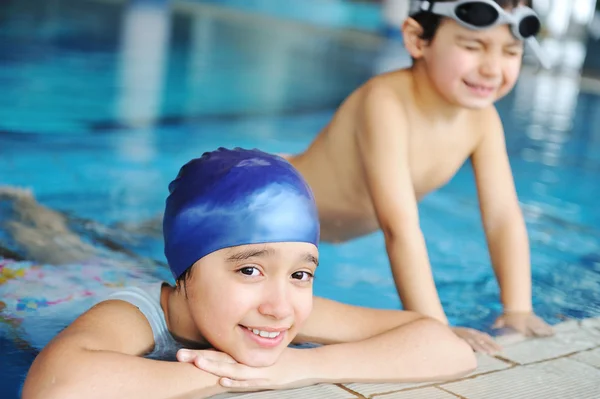 Дети в синей воде бассейна, лето для развлечений — стоковое фото