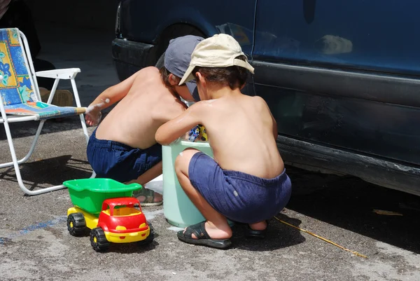 Spela runt bilen och städning, barnen sommartid — Stockfoto