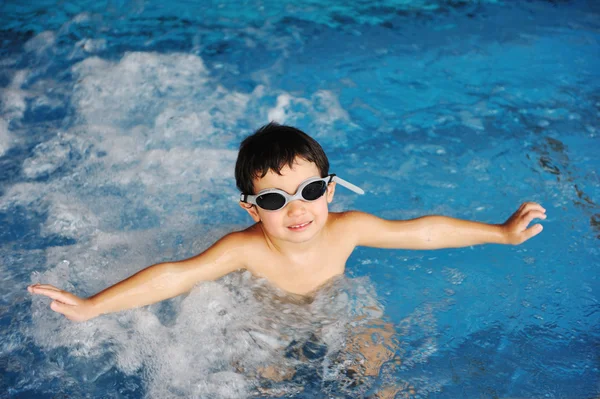 Kis aranyos fiú kék víz az uszoda, nyári időtöltés szórakozásból — Stock Fotó