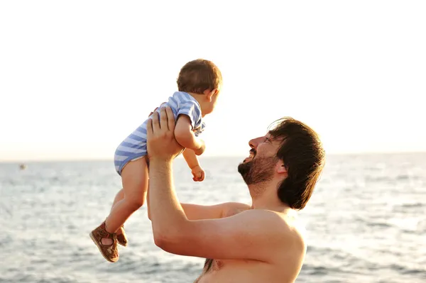 Atya dobtak a gyerek a levegő a strandon — Stock Fotó