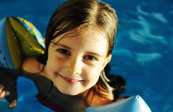 Little cute girl in blue water of the swimming pool, summer time for fun — Stock Photo, Image