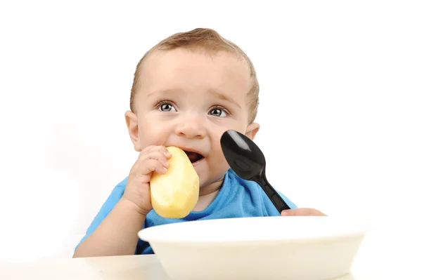 Ravasz imádnivaló egy éves baba, zöld szeme asztalnál eszik, kanál és — Stock Fotó