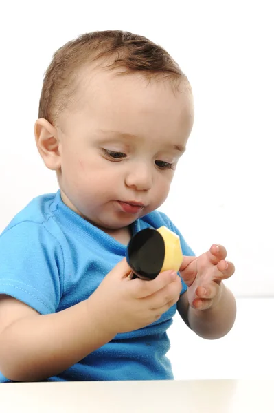 Ravasz imádnivaló egy éves baba, zöld szeme asztalnál eszik, kanál és — Stock Fotó