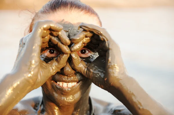Starší žena užívat přírodní minerální bahno na tváři pocházel z — Stock fotografie