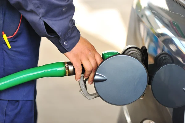 Mão masculina enchendo o carro com combustível em uma estação de abastecimento — Fotografia de Stock