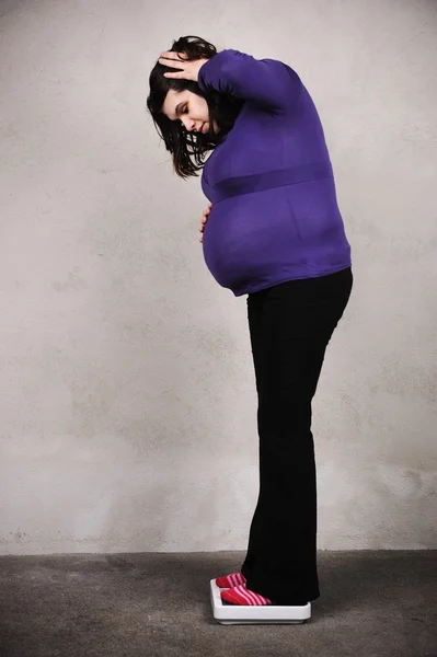 Pregnant woman weighing on scale — Stock Photo, Image