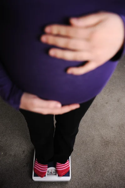 Hamile kadının üzerinden ağırlığında — Stok fotoğraf