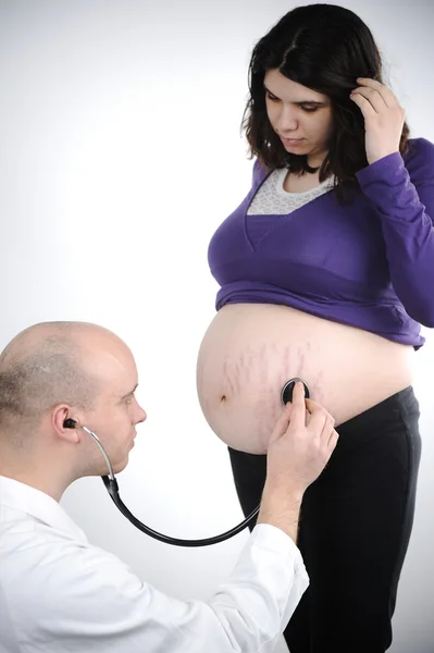 Врач концентрируется на обследовании беременности стетоскопом — стоковое фото