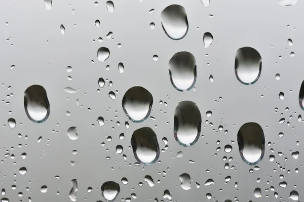Gotas de água grandes naturais em vidro de janela — Fotografia de Stock