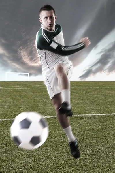 Jogador de futebol no campo jogando com uma bola — Fotografia de Stock