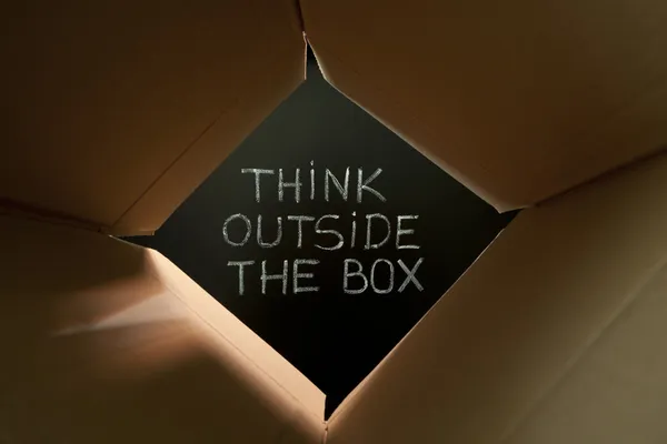 Pense fora da caixa no Blackboard — Fotografia de Stock