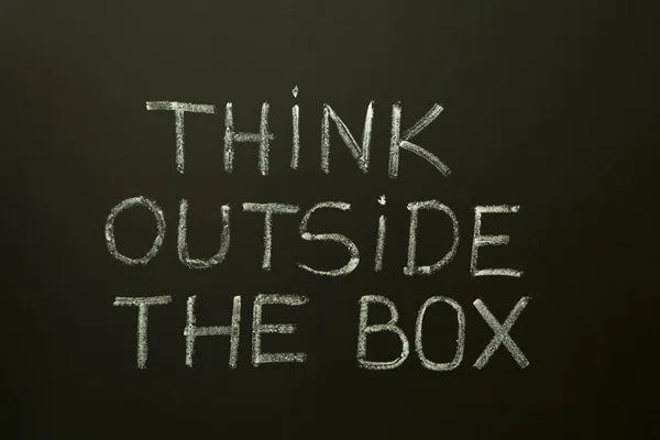 Denk buiten de doos op een schoolbord — Stockfoto