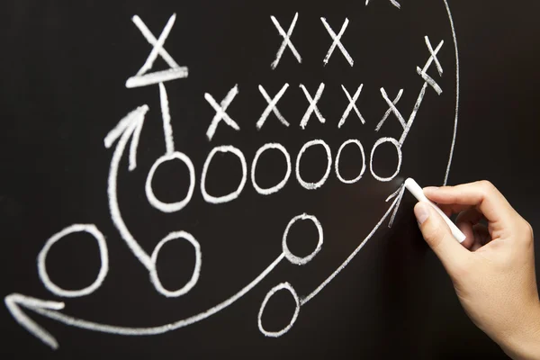 Treinador desenhando uma estratégia de playbook de futebol americano — Fotografia de Stock