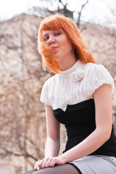 Bela jovem mulher de cabelo ruivo colocando fora sua língua — Fotografia de Stock