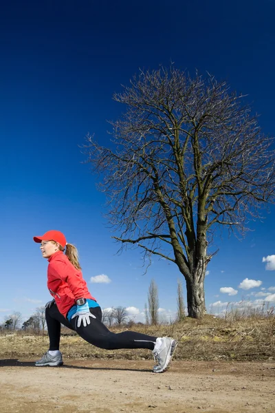 Stretching after cross country running — Stock Photo, Image