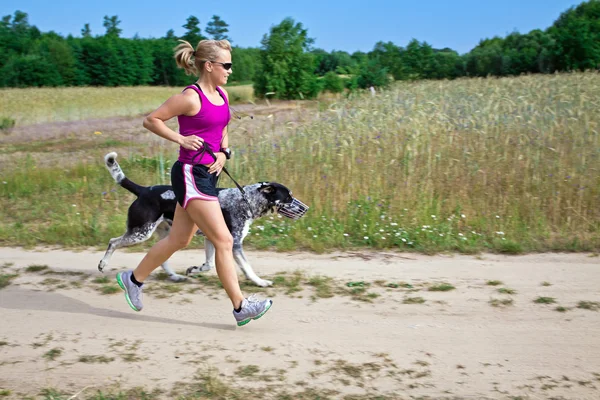 Frau läuft mit Hund — Stockfoto