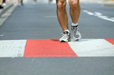 Man running in marathon on city street clipart