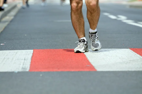 Человек, бегущий в марафоне по городской улице — стоковое фото