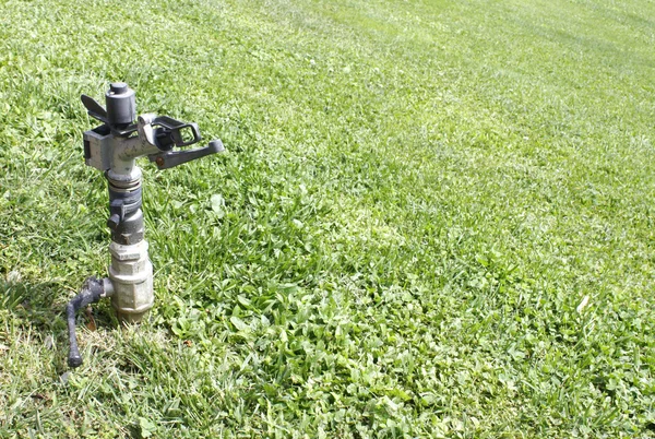 Wasserhahn mit Gras Hintergrund — Stockfoto