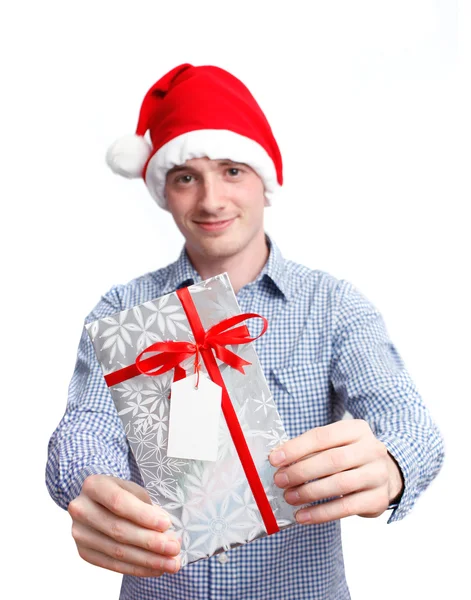 举行圣诞礼物的圣诞老人帽的男人 — 图库照片