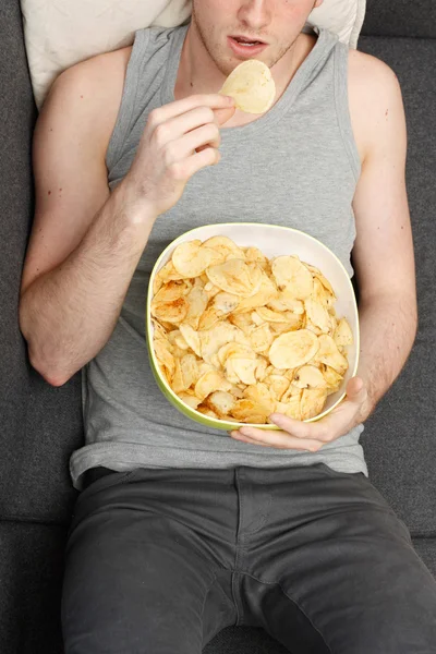 Человек ест чипсы — стоковое фото