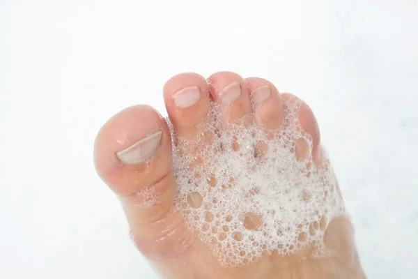 Foot in a foam — Stock Photo, Image