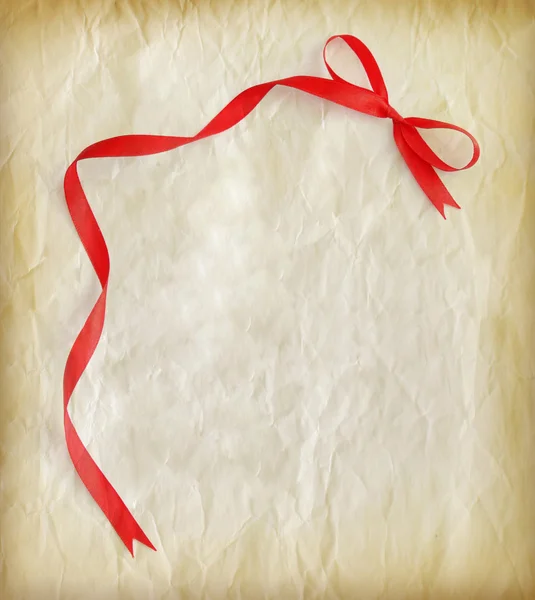 Red ribbon on old paper — Stock Photo, Image